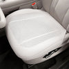 A white breathable car seat cushion is shown in a close-up view inside a vehicle.