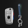 Juego de funda para llave de coche plateada con correa de cuero y anillo metálico.