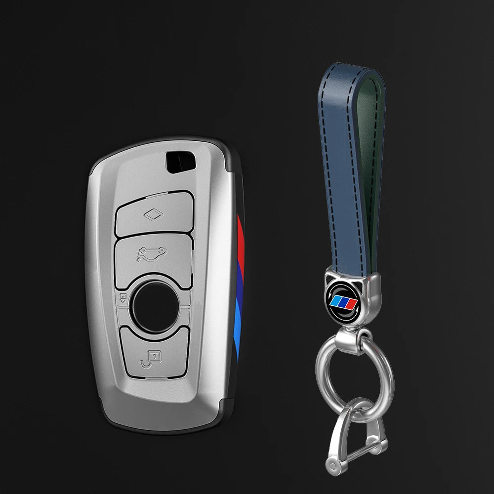 Juego de funda para llave de coche plateada con correa de cuero y anillo metálico.