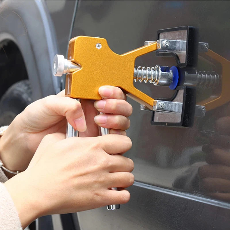 A hand is using a professional car dent repair puller kit to open a car door lock.