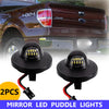 Two pairs of mirror LED puddle lights for a truck are shown against a background of a maroon pickup.