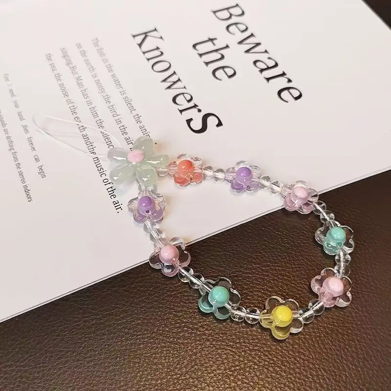 A bracelet made of round beads in various pastel colors is displayed on a white paper.