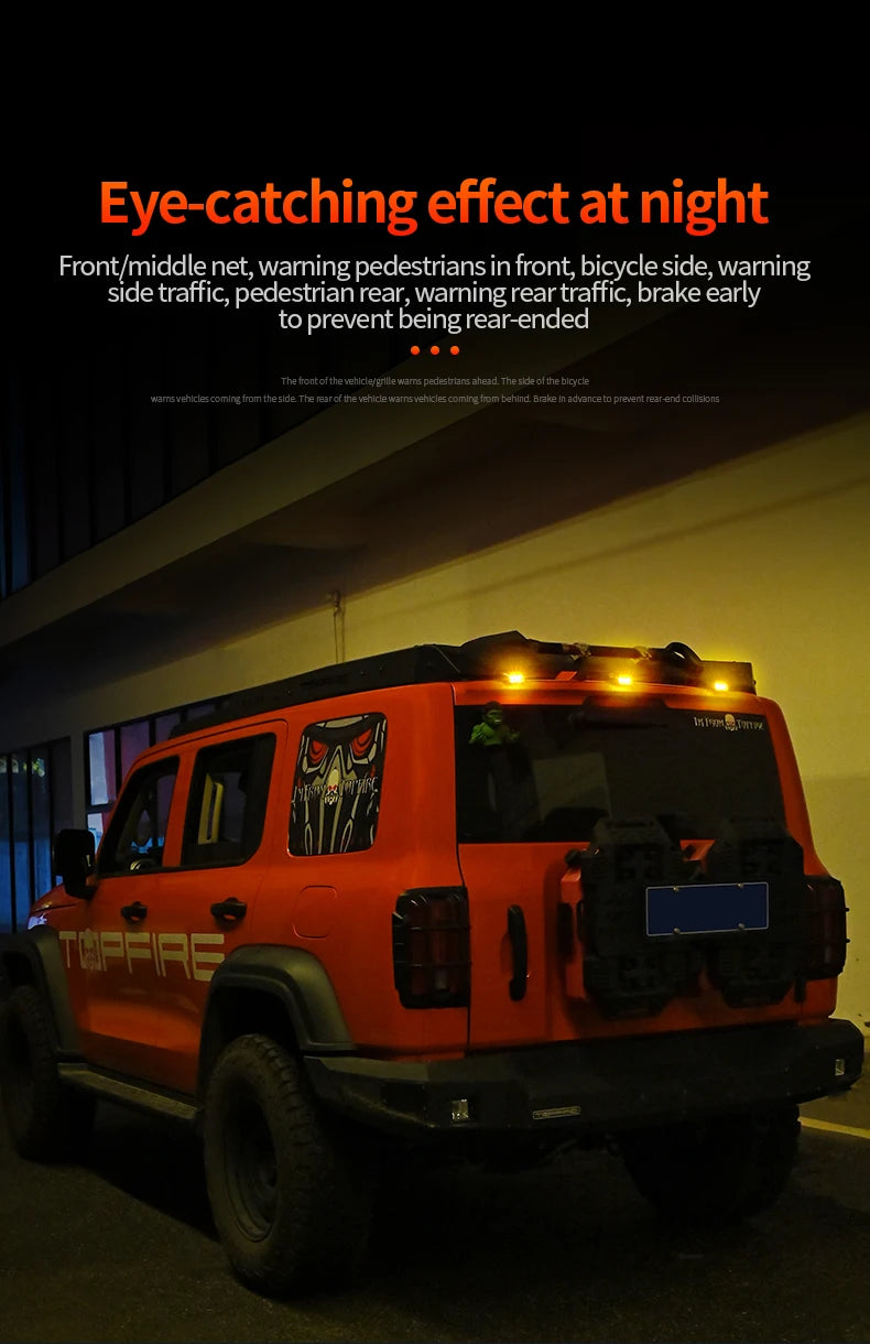 An orange Jeep with roof-mounted strobe warning lights is parked outdoors at night.