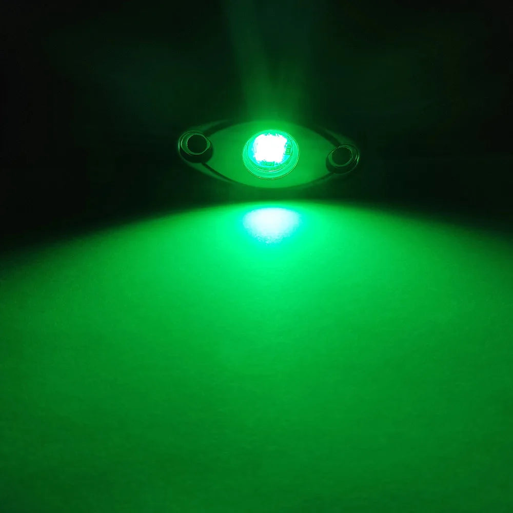 A close-up of a 9LED RGB underbody rock light illuminating a bright green beam.