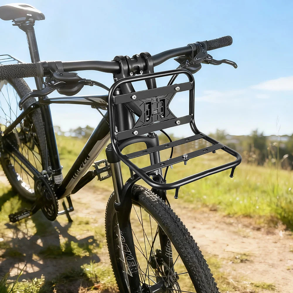 A black durable iron front rack mounted on a bicycle frame outdoors.
