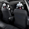 Two black car headrests with white panda face covers are visible in a vehicle interior.