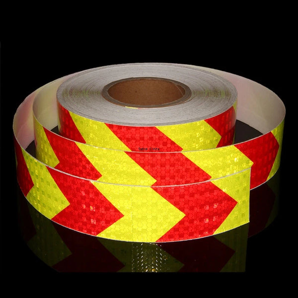 Roll of high-visibility fluorescent yellow and red reflective safety tape on a black background.