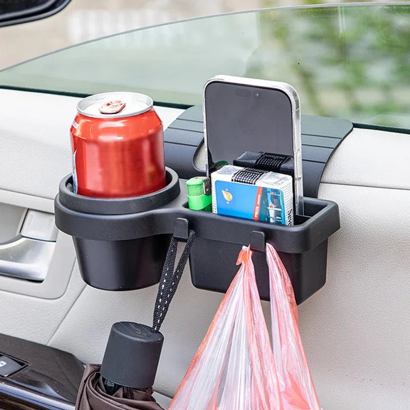 A black car door storage organizer holds a can and a smartphone, with a plastic bag hanging below.