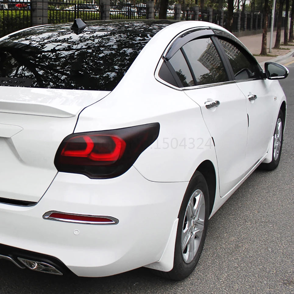 A white sedan with a black tint on the roof and taillights, showing a vinyl decal for car lights.