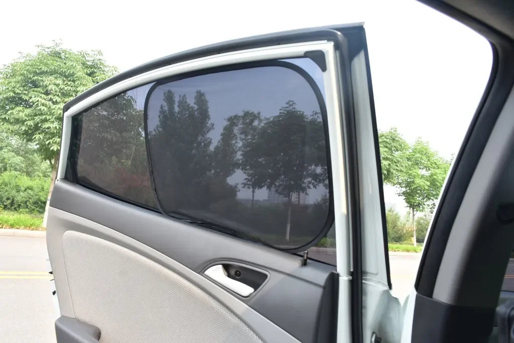 A side view of a car window with a black sun shade mesh installed.