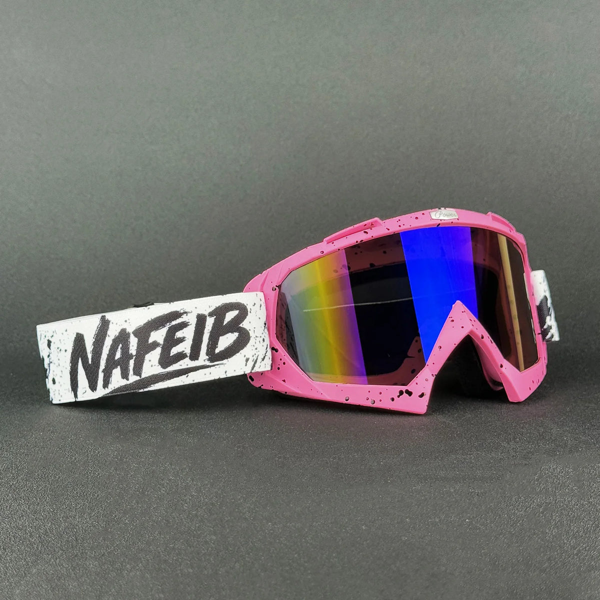 Pinkes Motorrad und Offroad-Schutzbrille mit weißem Etikett auf dunklem Grau.