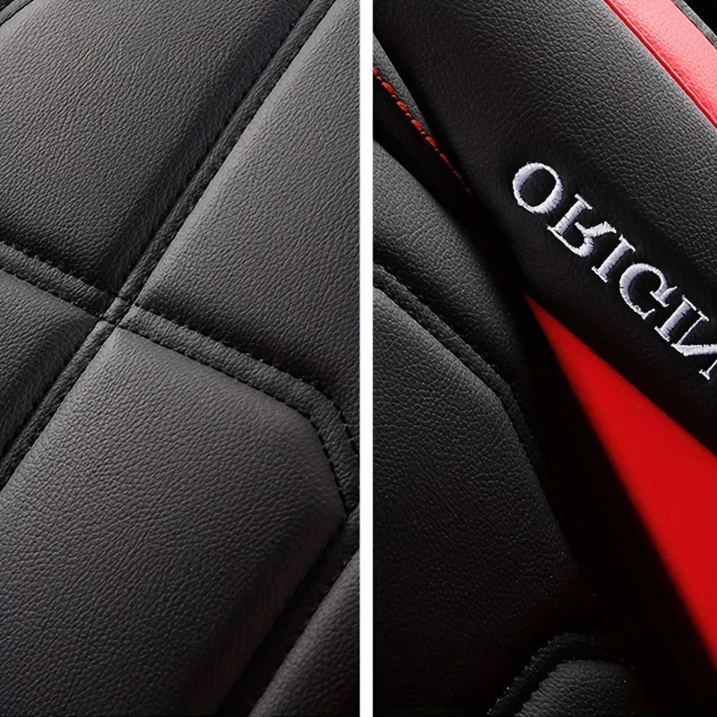Close-up of black quilted leather car seat covers with red stitching and white lettering