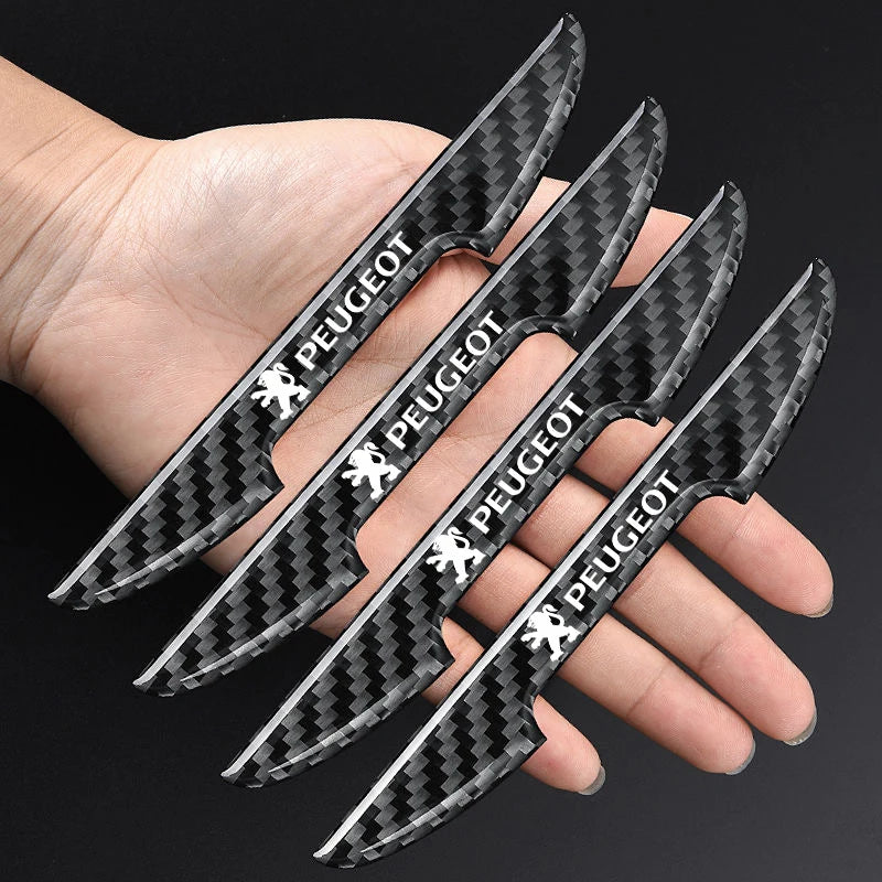 Una mano sostiene varias pegatinas protectoras para manijas de puertas de fibra de carbono negra y gris.