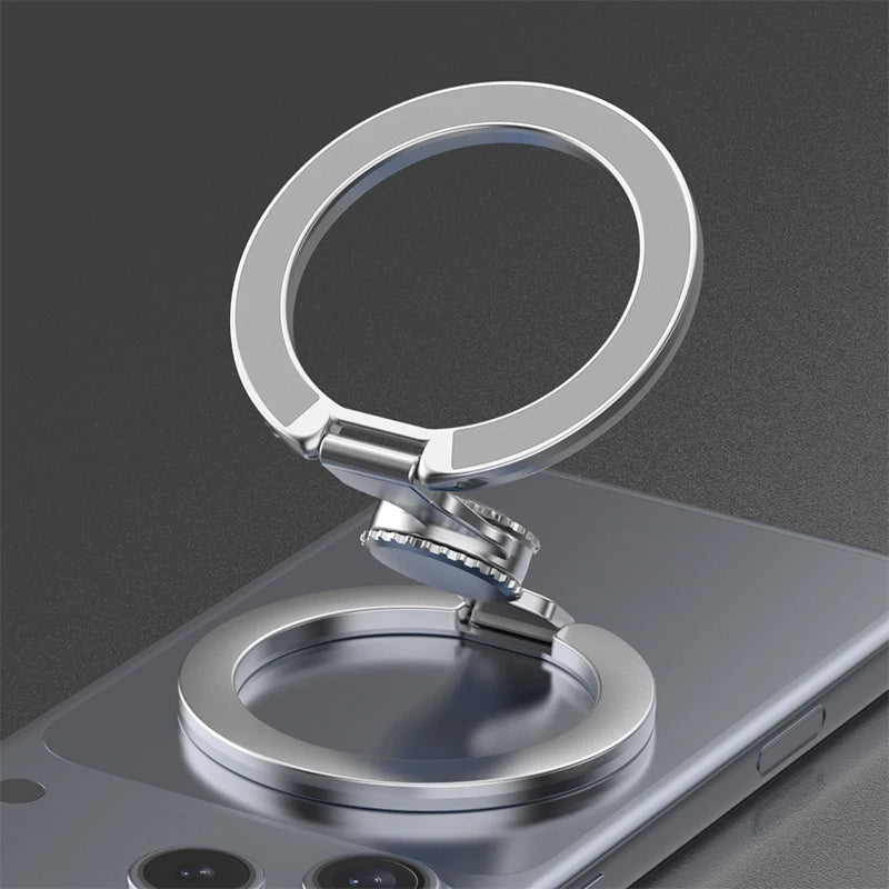 A silver magnetic phone ring stand with a dual-sided grip resting on a smartphone.