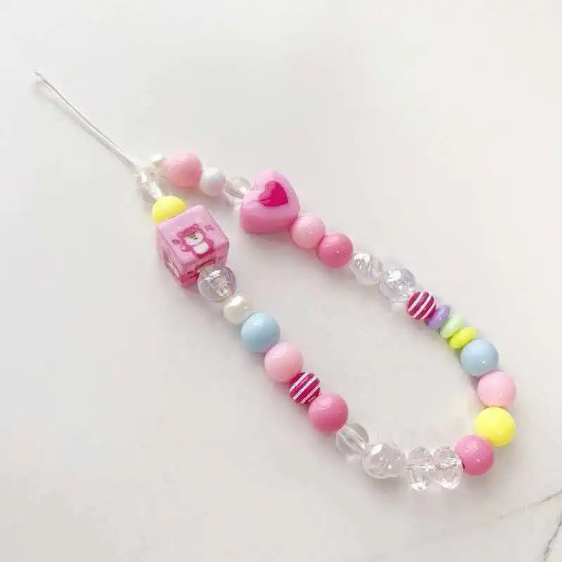 A beaded lanyard featuring round pink, white, and yellow beads with a pink rectangular pendant.