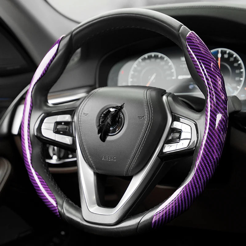 Vue rapprochée d'un volant noir recouvert d'un protecteur en fibre de carbone violette à l'intérieur d'une voiture.