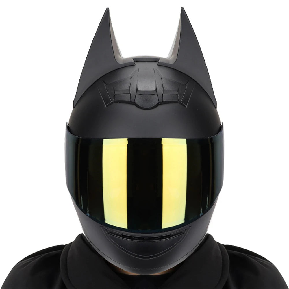 A black full face motorcycle helmet with a reflective yellow visor and pointed horns.