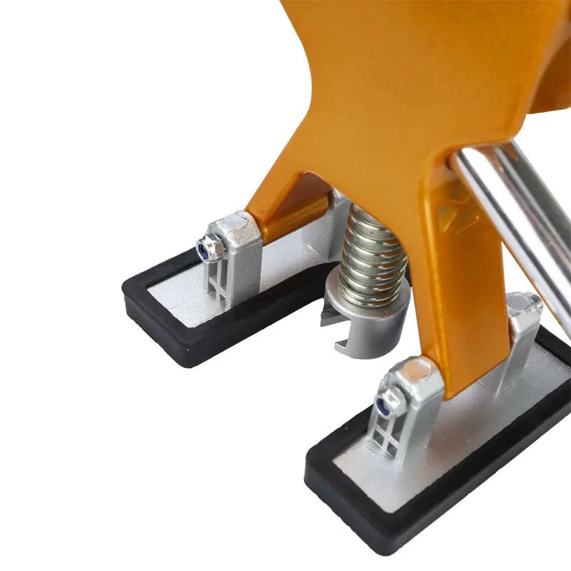 Close-up view of a yellow professional car dent repair puller kit with silver and black components.