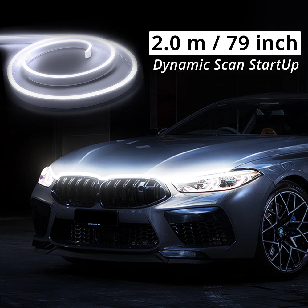 A close-up of a car's front grille and hood showing a bright white LED light strip installation.