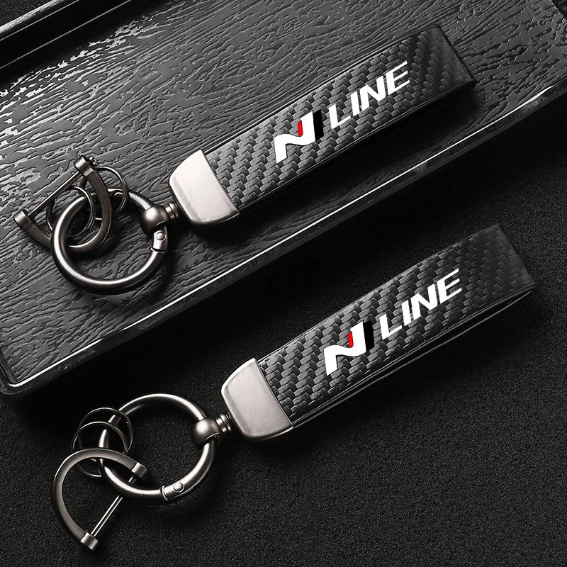 A close-up shot of a black carbon fiber style keychain with silver hardware and white N LINE lettering.