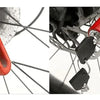 Close-up of a red heavy duty motorcycle wheel disc brake lock attached to a bicycle wheel.