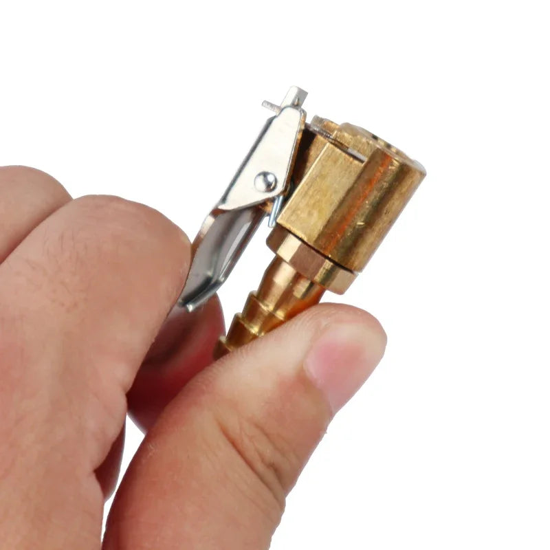 A hand holds a portable inflatable tire pump with a metal nozzle and pump mechanism.