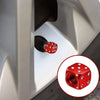 Close-up of an aluminum dice valve cap being installed on a tire valve stem.
