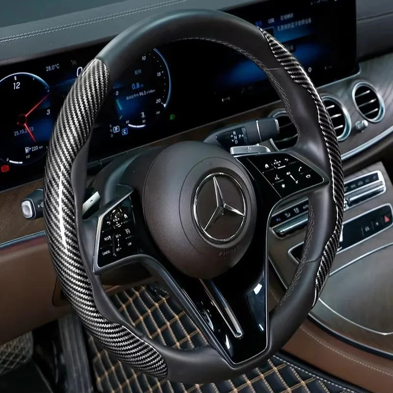 Nahaufnahme eines schwarzen Lenkrads mit Lederummantelung und Carbonfaserakzenten im Autointerieur.