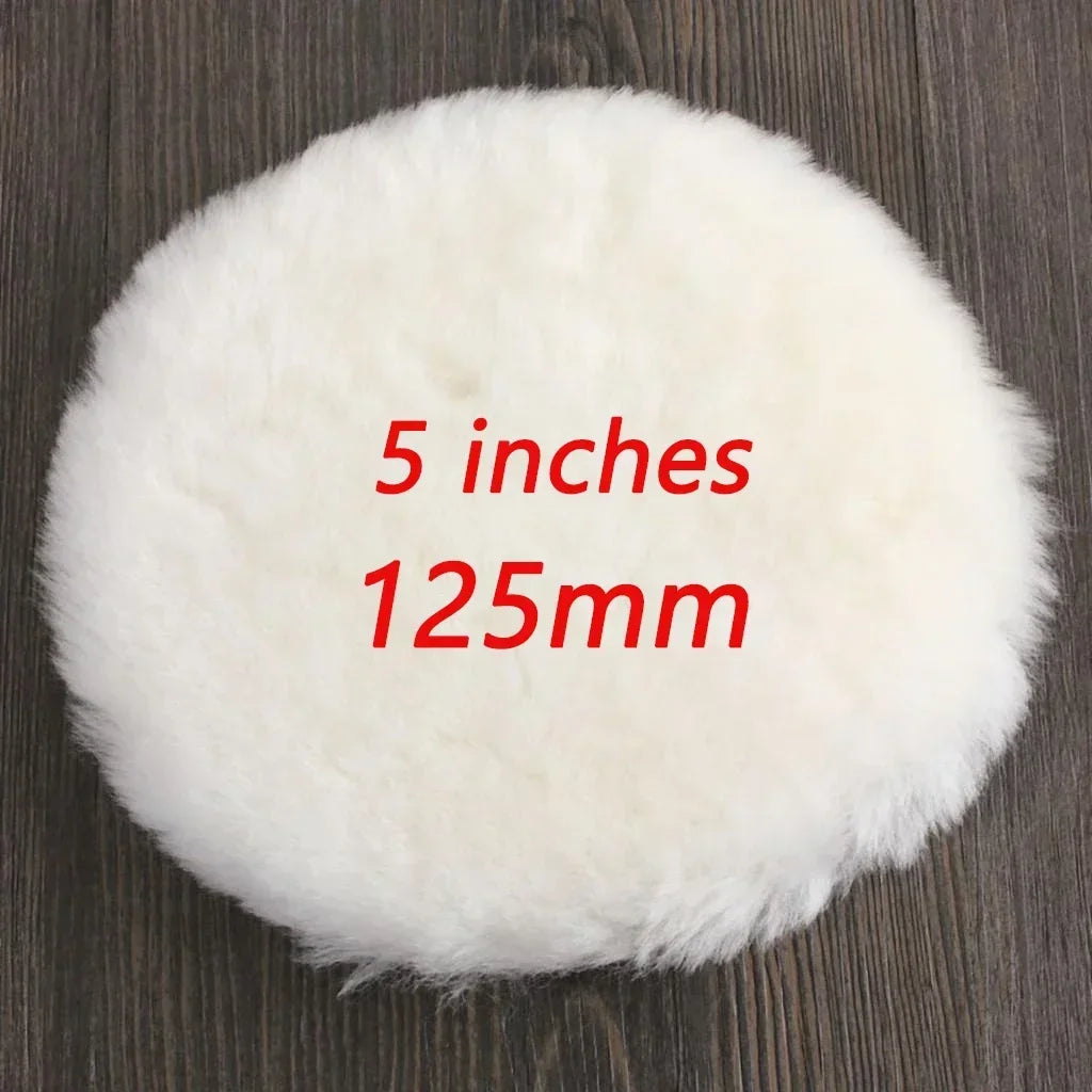 A round, white, fluffy polishing disc measuring 5 inches or 125mm resting on a dark wooden surface.