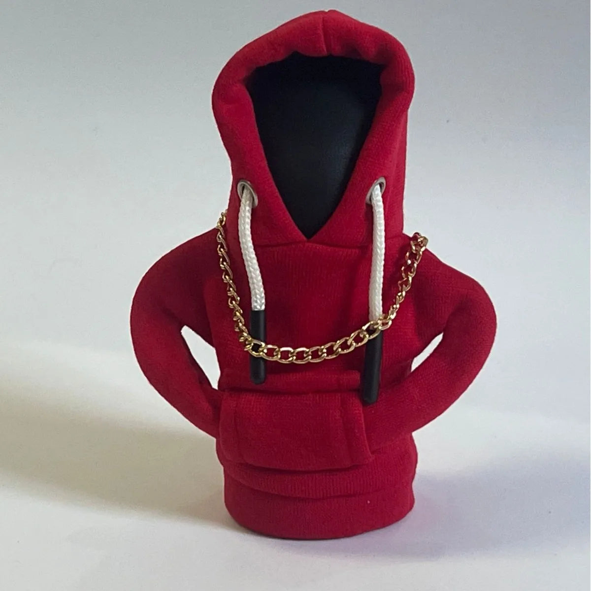 A red cozy knit gear shift cover for manual transmission with white drawstrings and a gold chain.