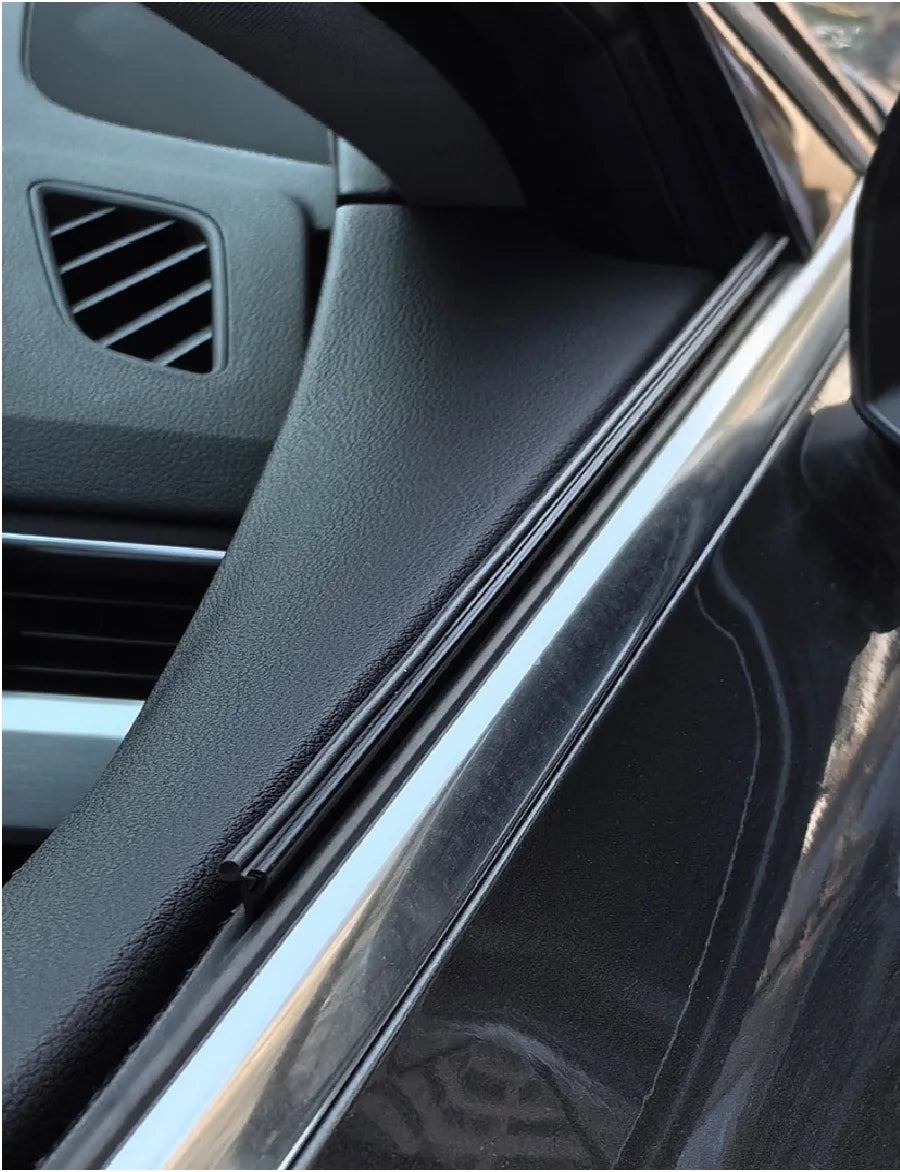 Close-up view of a black car window with a wiper blade assembly visible.
