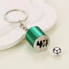 A green cylindrical keychain with a silver ring and a metal ball, designed for desk stress relief.