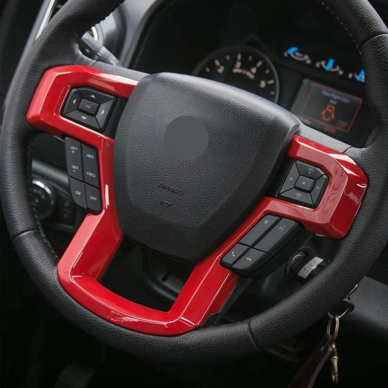 Close-up of a red ABS steering wheel cover trim on a black steering wheel.