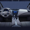 Vue intérieure d'une voiture montrant le volant, le tableau de bord et la console centrale avec un pare-soleil visible sur le