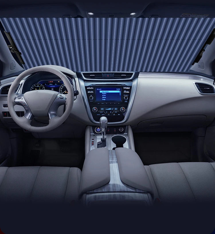 Vue intérieure d'une voiture montrant le volant, le tableau de bord et la console centrale avec un pare-soleil visible sur le
