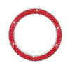 A circular cover decorated with red rhinestones and sparkling accents for a car start button.
