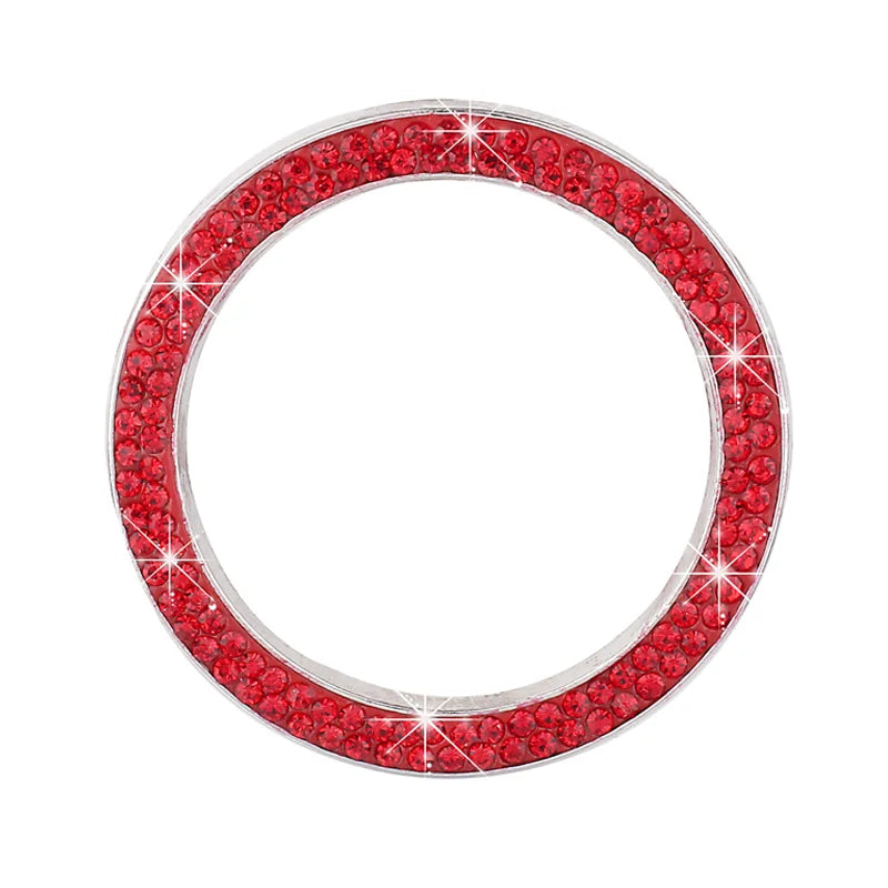 A circular cover decorated with red rhinestones and sparkling accents for a car start button.