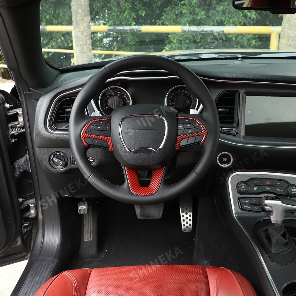 Interior view of a car showing a black steering wheel decoration cover and red leather seats.