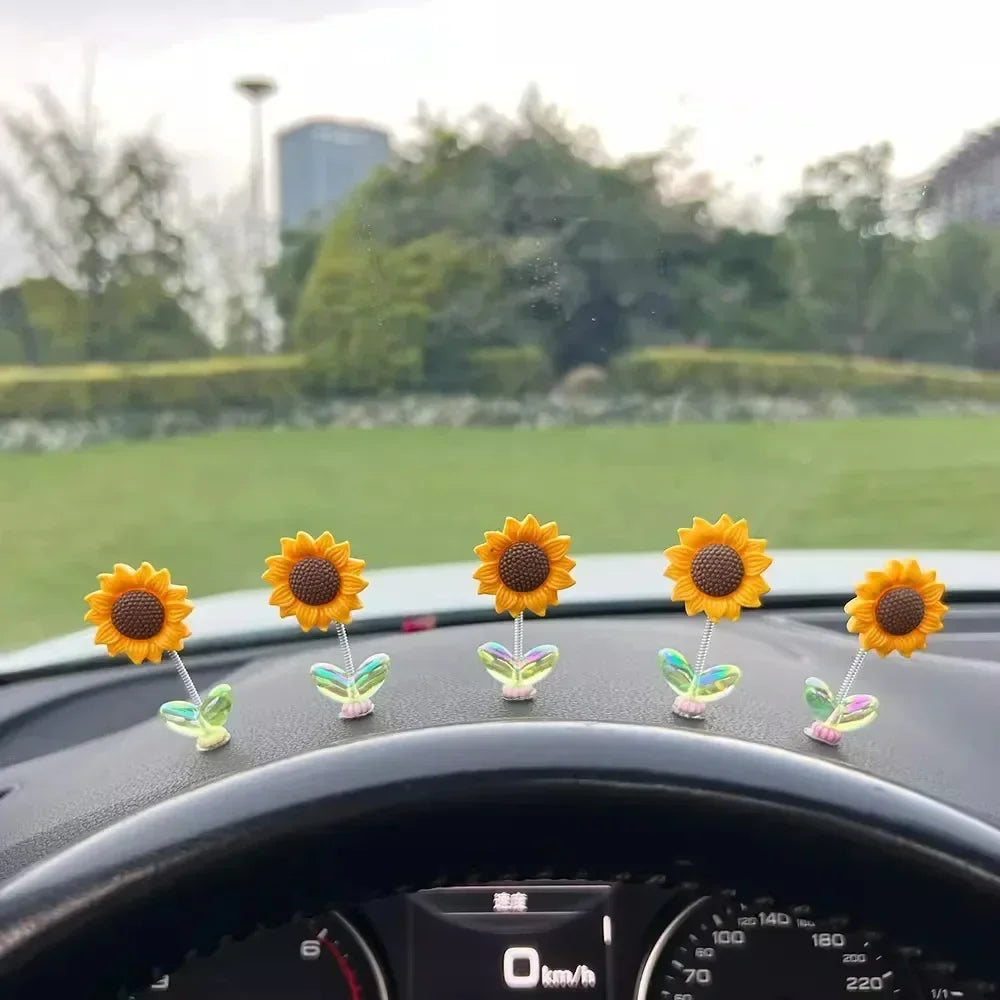Plusieurs petits ornements de tournesol jaunes sont placés sur le tableau de bord d'une voiture.