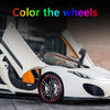 A white sports car with its wheels open, showing a red rim protector strip on the wheel.