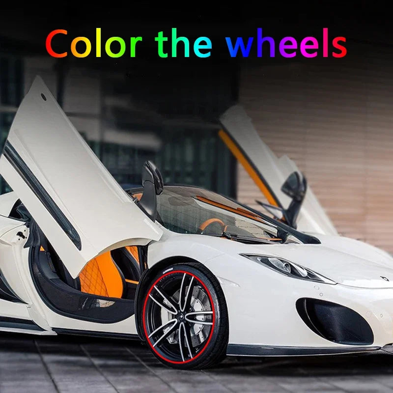 A white sports car with its wheels open, showing a red rim protector strip on the wheel.