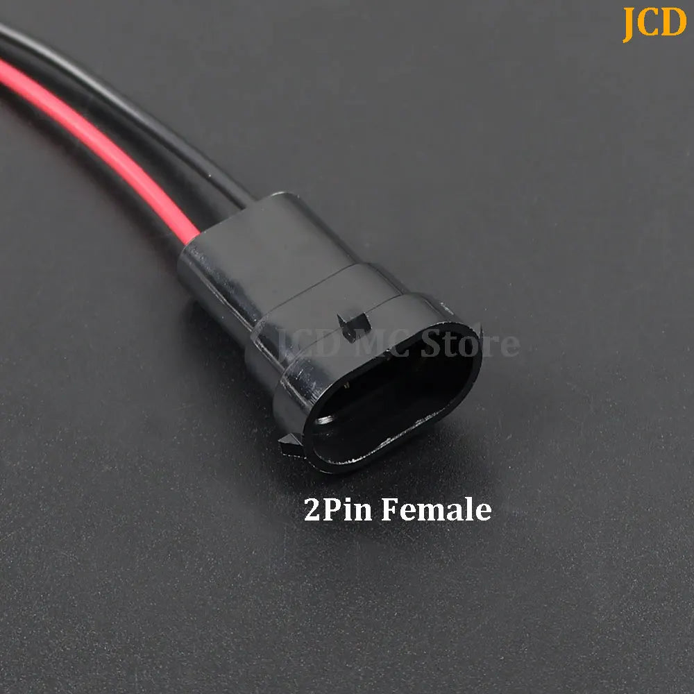 A black 2-pin female wiring harness with a red cable is shown against a dark background.