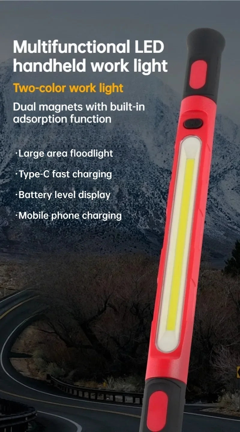 A red and black multifunctional LED handheld work light with a bright yellow illumination, shown outdoors.