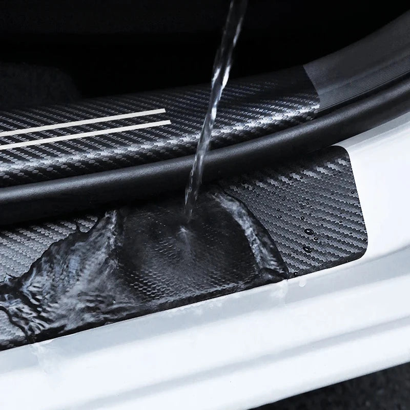 Close-up of a carbon fiber door sill protector being rinsed with water.