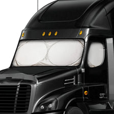 Close-up of a heavy duty foldable windshield sun shade installed on a black truck.