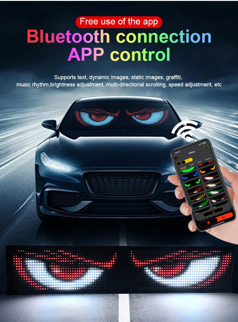 A hand holds a smartphone controlling an LED pixel panel light that mimics an angry eye design on a car's front grille.
