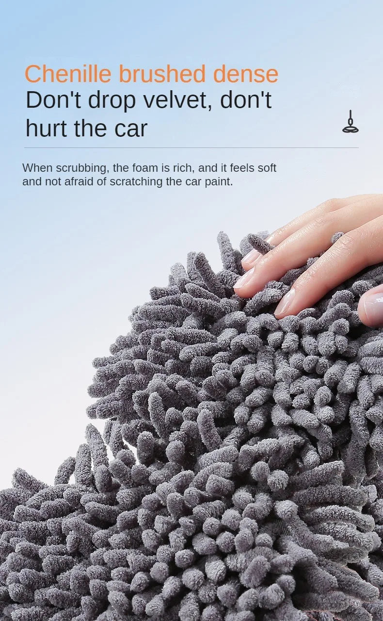 Close-up of a dense, dark gray, bristled brush used for car washing.