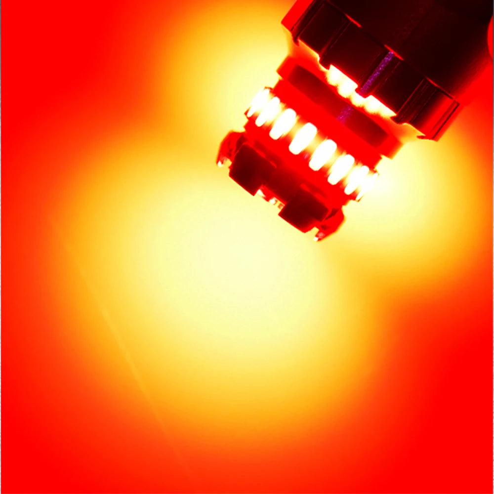 Close-up view of an LED brake and reverse light bulb with a bright, intense orange glow.