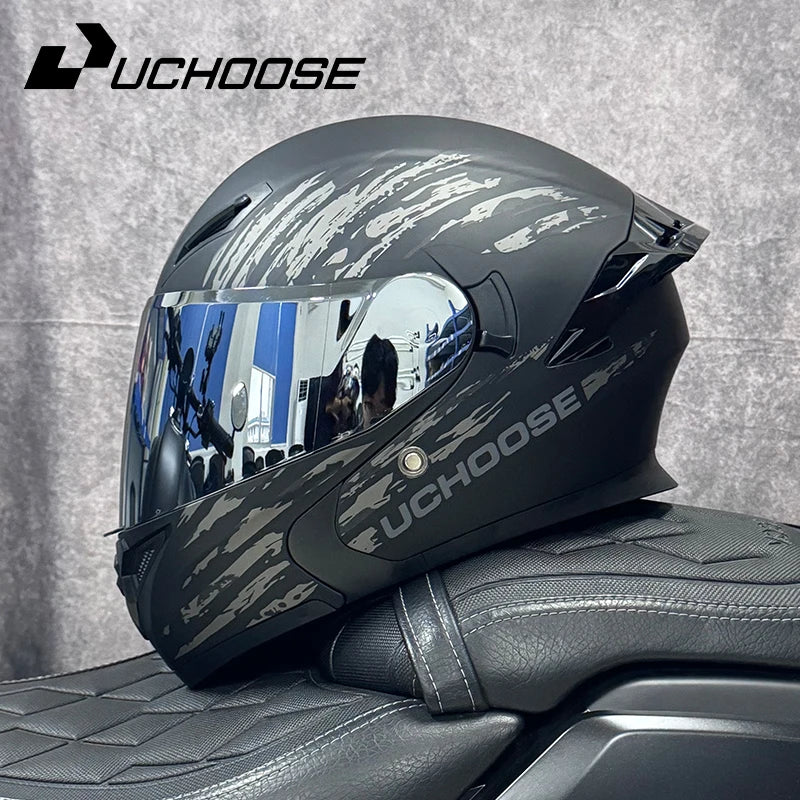 Un casque moto modulaire noir avec motif camouflage gris sur un siège de moto.