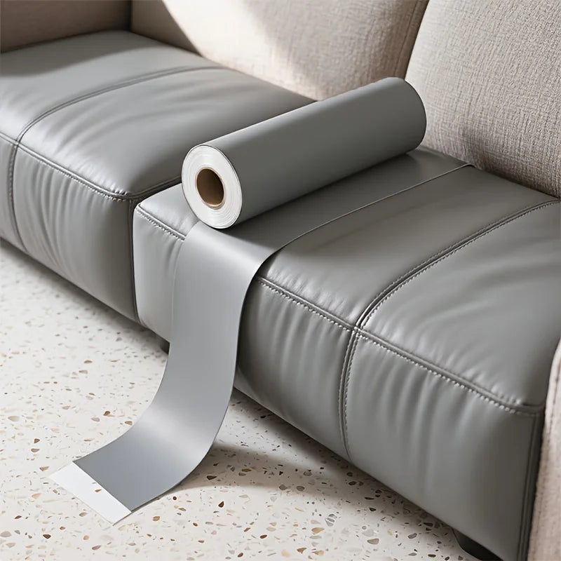 A roll of gray self-adhesive PU leather repair patches is placed on a light-colored leather sofa cushion.
